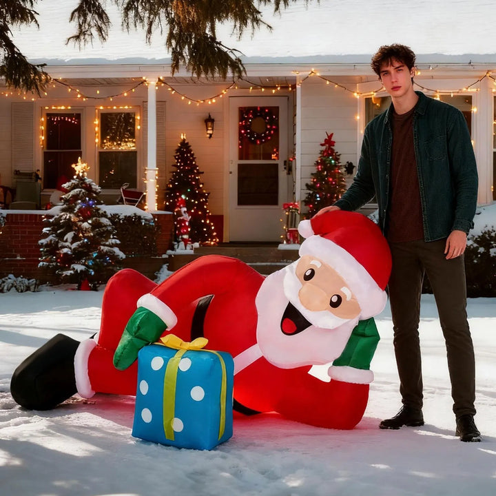 Inflatable Santa lying beside a gift box