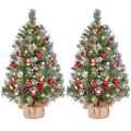 Two frosted tabletop trees with burlap bases