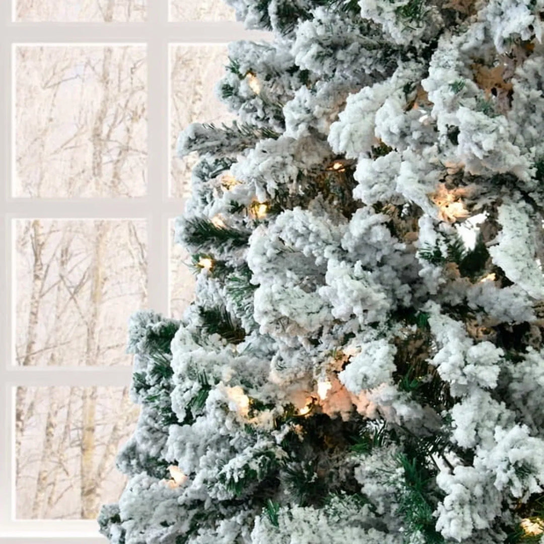 Snow-flocked pre-lit tree glowing white