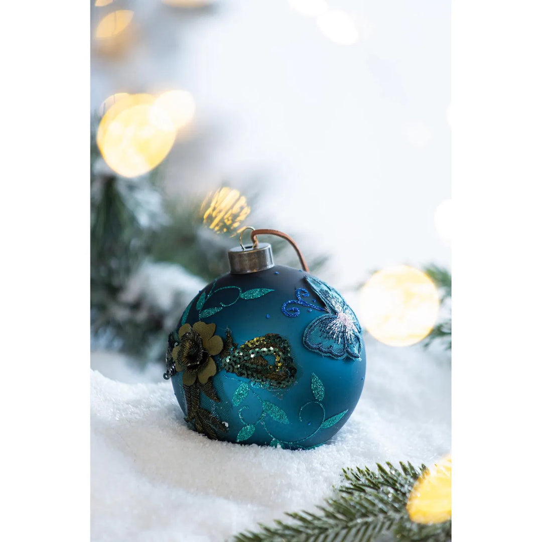 Four teal glass Christmas baubles with glitter