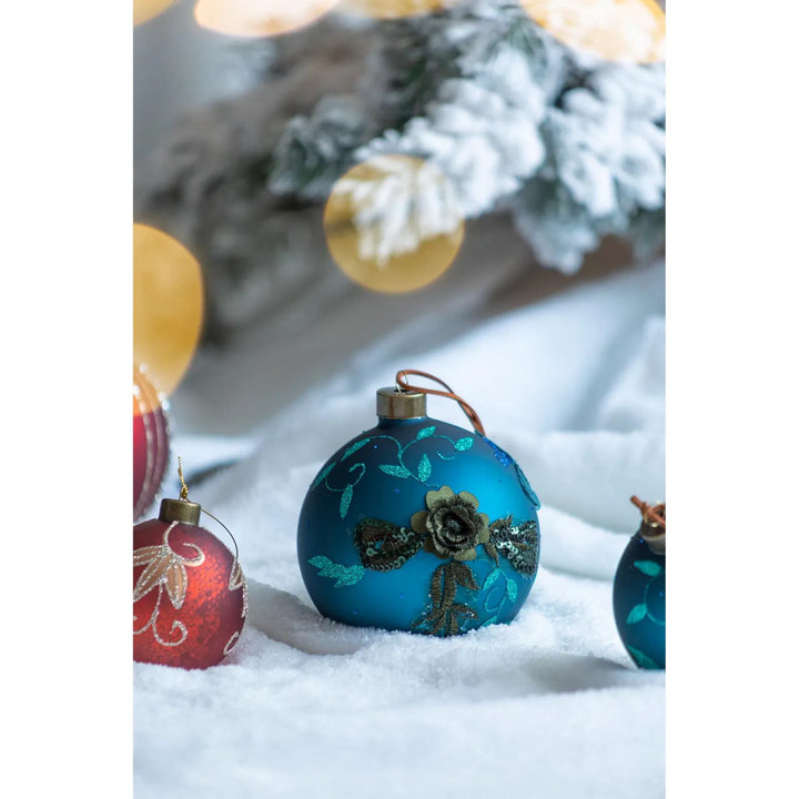 Four teal glass Christmas baubles with glitter