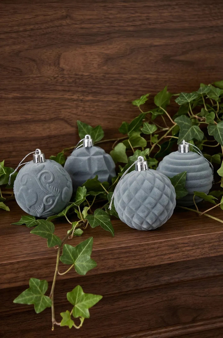 Twelve grey velvet Christmas baubles with patterns