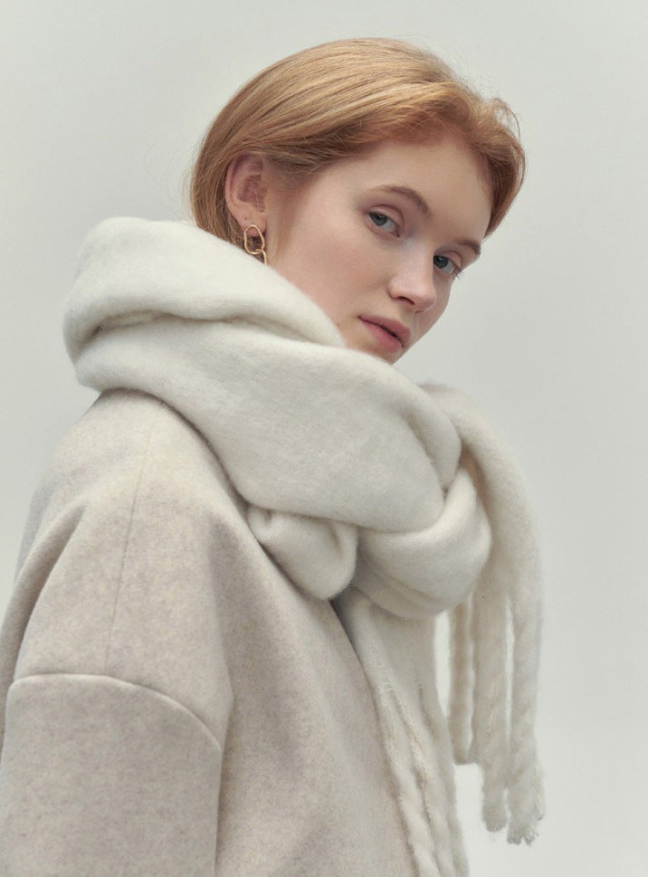 Woman wearing long ivory scarf with tassels
