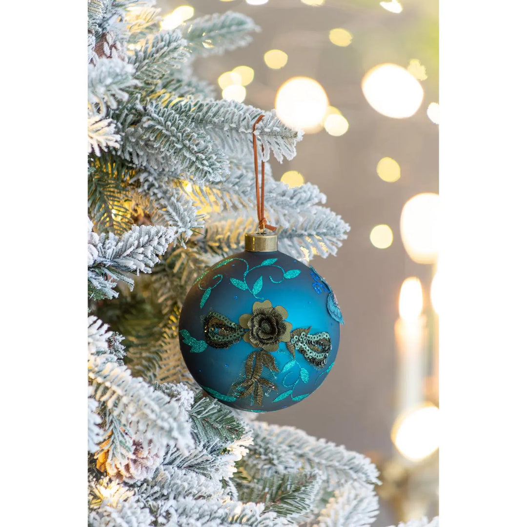 Four teal glass Christmas baubles with glitter